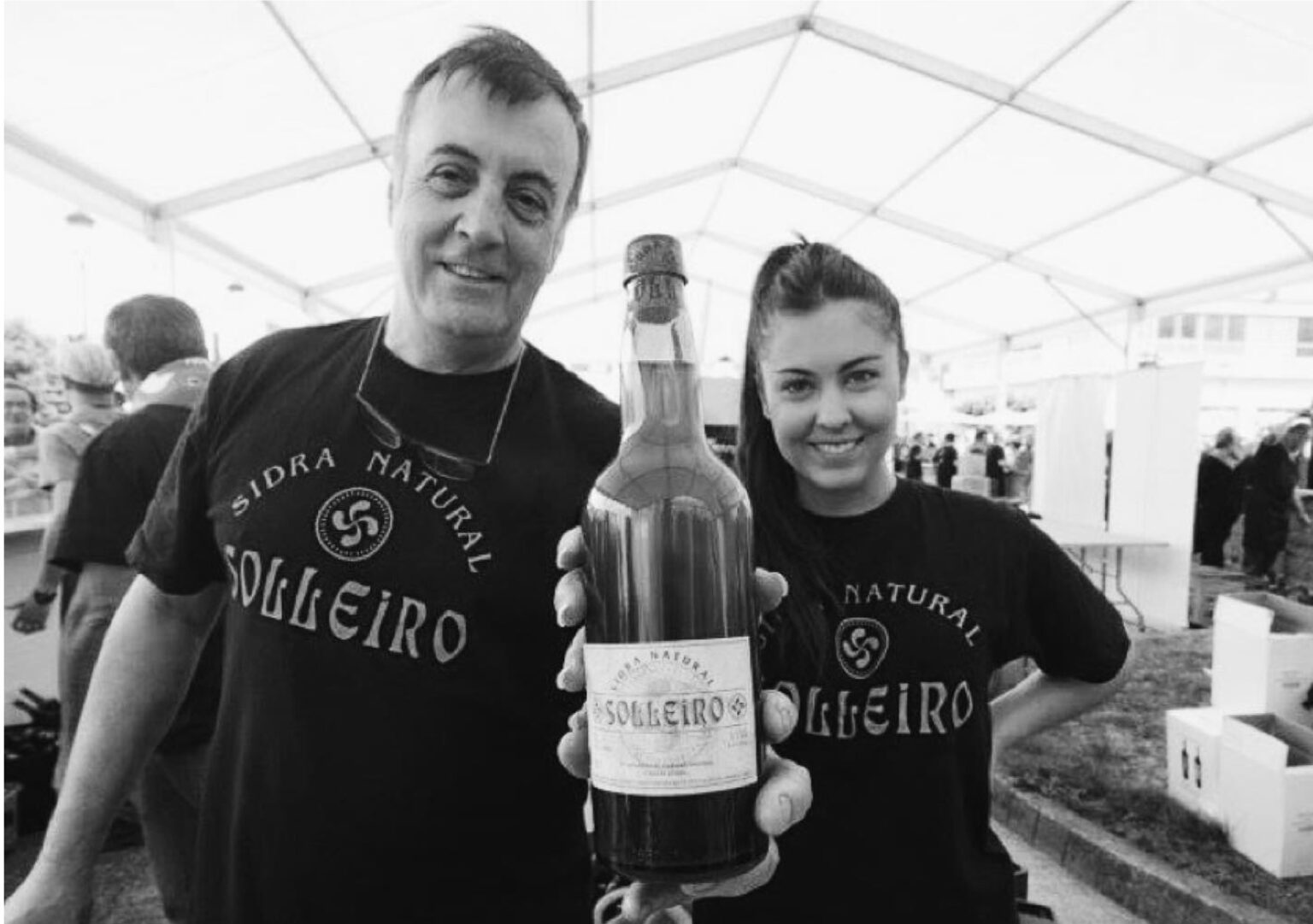 Hombre y mujer con una botella de Sidra