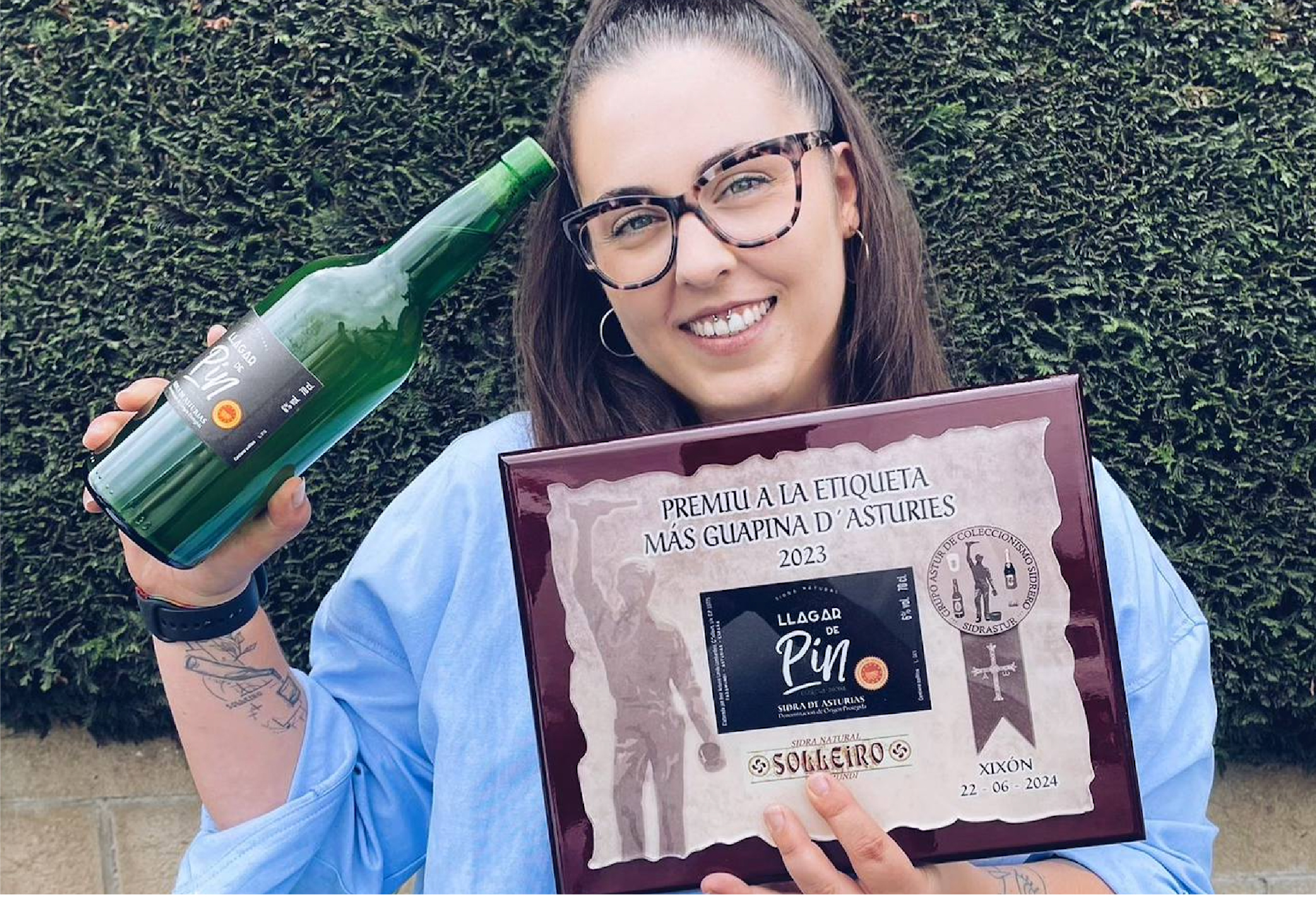 Chica con botella de sidra y premio a la etiqueta más guapina d'Asturies
